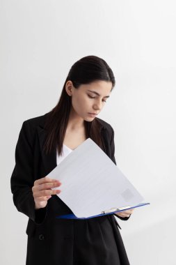 Güzel esmer kadın ofiste kağıtlarla çalışıyor.