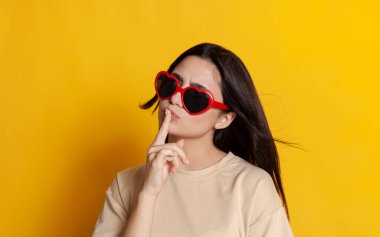 Parlak güneş gözlüklü güzel esmer düşünceli poz veriyor.