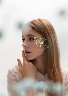 Çiçekli güzel bir kızıl kızın portresi.