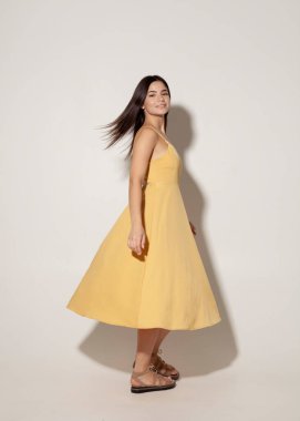 Sarı gece elbisesi içinde dans eden güzel esmer