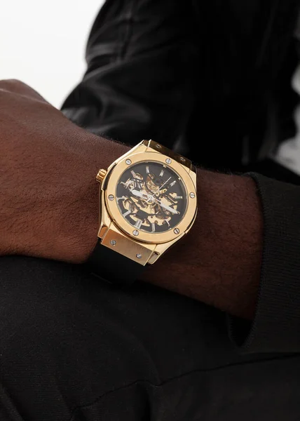 Afrikalı bir Amerikalının elinde altın adam saati var.