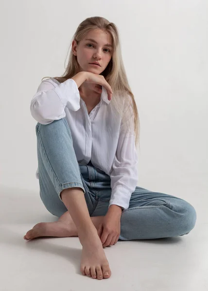 Bela Loira Uma Camisa Branca Jeans Senta Chão — Fotografia de Stock