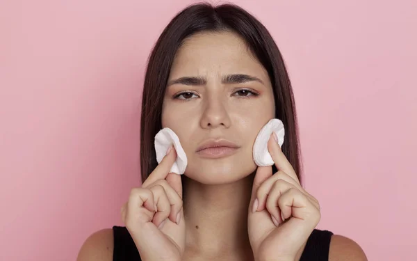 Hermosa Morena Elimina Maquillaje Con Almohadillas Algodón Sobre Fondo Rosa —  Fotos de Stock