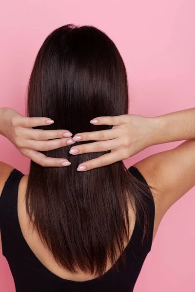 Brunette Met Lang Goed Verzorgd Haar Een Roze Achtergrond Staat — Stockfoto