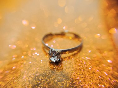 Soyut altın bokeh arkaplanlı nişan yüzüğü