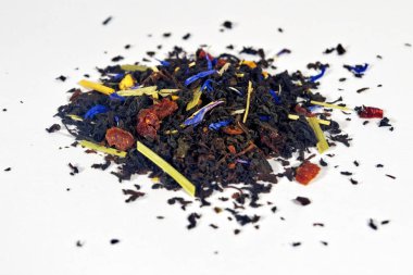 Aromatik doğal katkı maddeleri içeren kuru siyah çay yaprakları beyaz arka planda izole edilir..