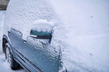 Kalın bir kar tabakasının altındaki araba. Kalın bir kar tabakasıyla kaplı bir araba. Yakın plan. Kış.