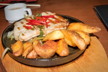 Kızarmış patates ve soğanlı domuz bifteği, dökme demir Brezilya peyniri..