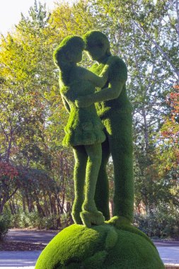 Şehir parkındaki yapay çimlerden yapılmış kentsel bir heykel. Genç bir adam ve aşık bir kız..