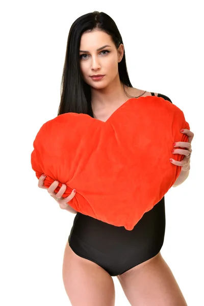 Beautiful woman with big red heart pillow — Stock Photo, Image