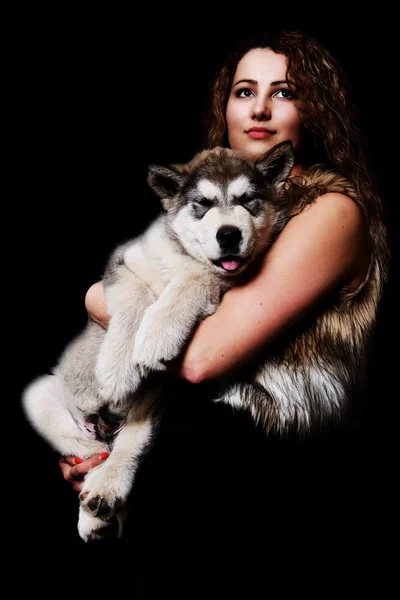 Mulher bonita com cão jovem Malamute — Fotografia de Stock