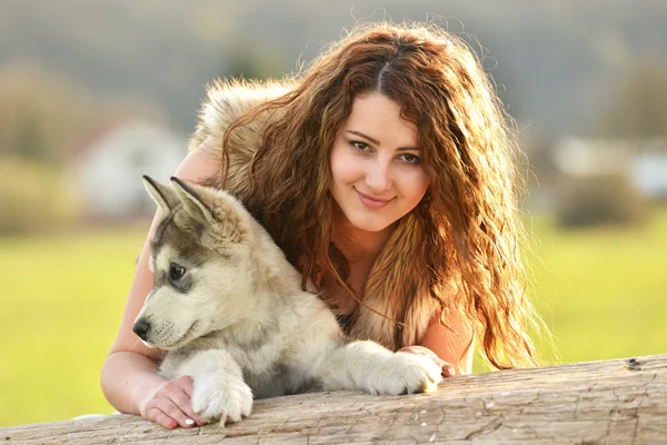 Bella donna con giovane cane Malamute — Foto Stock