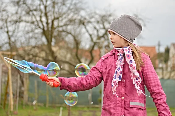 Kleines Mädchen mit Seifenblasen — Stockfoto