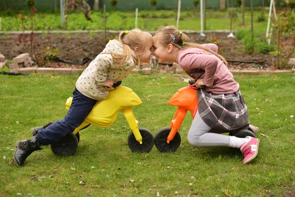 Twee meisjes op speelgoed fietsen — Stockfoto