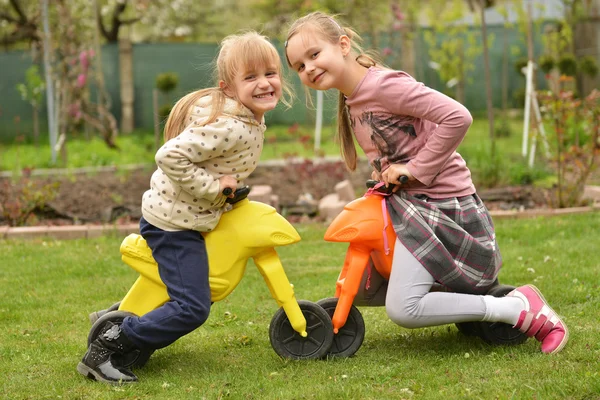 Zwei Mädchen auf Spielzeugfahrrädern — Stockfoto