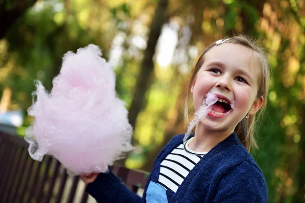Adorável menina comendo doces-fio dental ao ar livre no verão — Fotografia de Stock