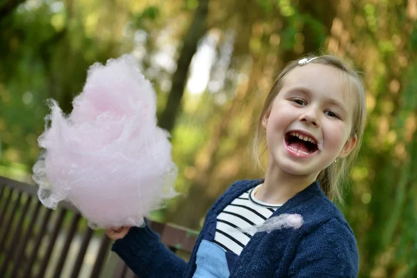 Adorable niña comiendo caramelo-hilo dental al aire libre en verano —  Fotos de Stock