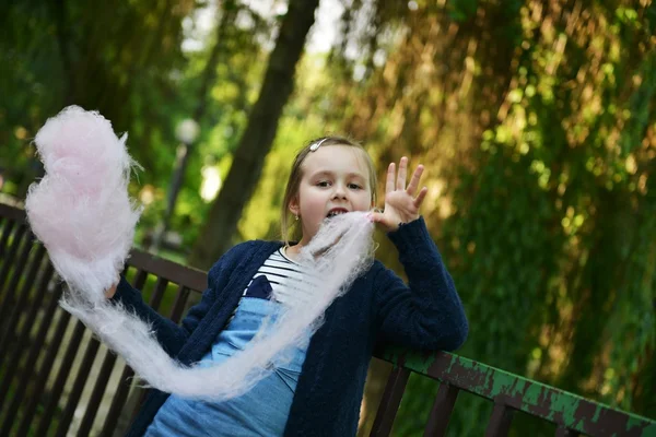 Adorable petite fille mangeant des bonbons-fil dentaire à l'extérieur en été — Photo