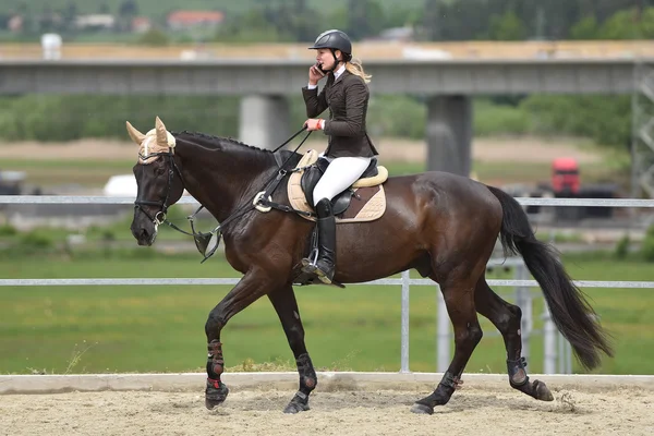 Mulher usando smartphone enquanto monta cavalo — Fotografia de Stock