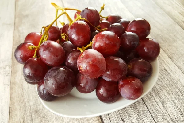 Uvas frescas sobre mesa de madera — Foto de Stock