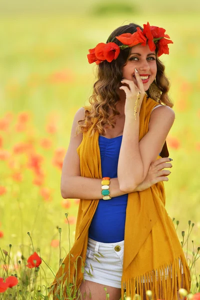 Kvinna poserar i blommande vallmo fält — Stockfoto