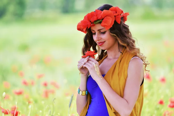 Mujer posando en campo de amapola floreciente — Foto de Stock