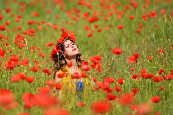 Mujer posando en campo de amapola floreciente —  Fotos de Stock