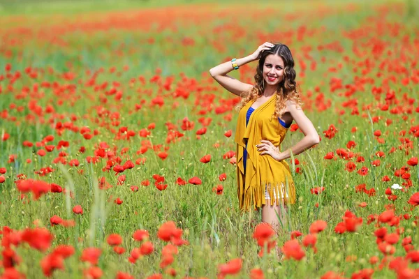 Kvinna poserar i blommande vallmo fält — Stockfoto