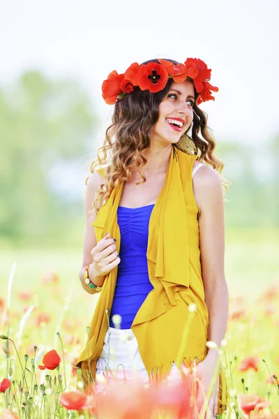 Kvinna poserar i blommande vallmo fält — Stockfoto
