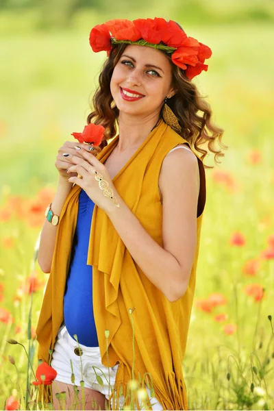 Mujer posando en campo de amapola floreciente — Foto de Stock