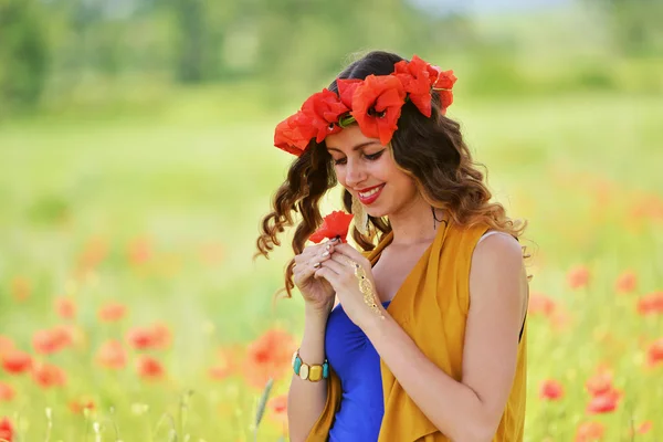 Mujer posando en campo de amapola floreciente — Foto de Stock