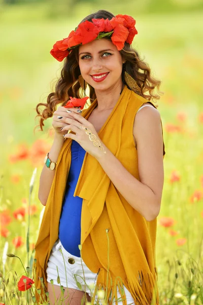 Mujer posando en campo de amapola floreciente — Foto de Stock