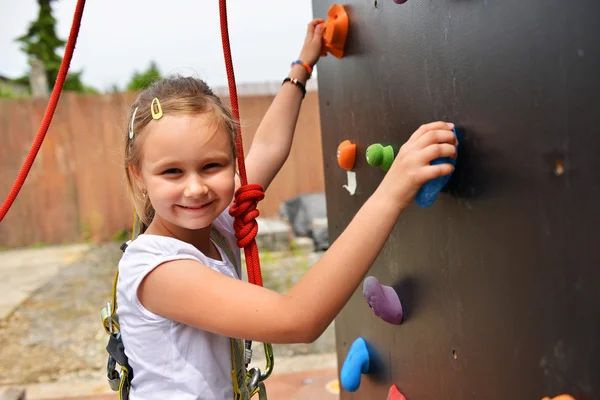 Little girl climbing the wall — Stock Photo, Image