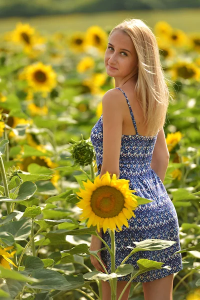Mooie vrouw omgeven door zonnebloemen — Stockfoto