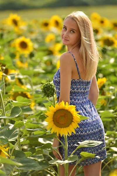 Beautiful woman surrounded by sunflowers — Stock Photo, Image