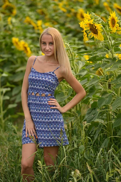 Beautiful woman surrounded by sunflowers — Stock Photo, Image