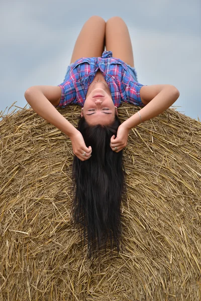 Une jeune cow-girl rêvant dans un champ de foin — Photo