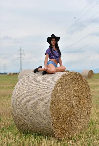 Mladí cowgirl snění v poli seno — Stock fotografie