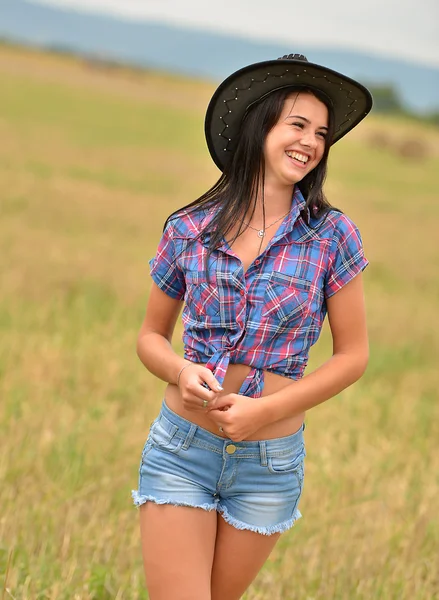 Ein junges Cowgirl träumt in einem Heufeld — Stockfoto