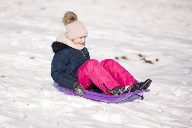 Küçük kız Bob 'la kayıyor ve karda düşüyor..