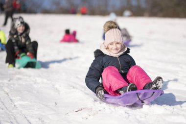 Küçük kız Bob 'la kayıyor ve karda düşüyor..