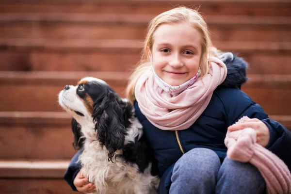 Cute Uśmiechnięta Dziewczynka Przytulając Psa Siedzi Drewnianych Schodach — Zdjęcie stockowe