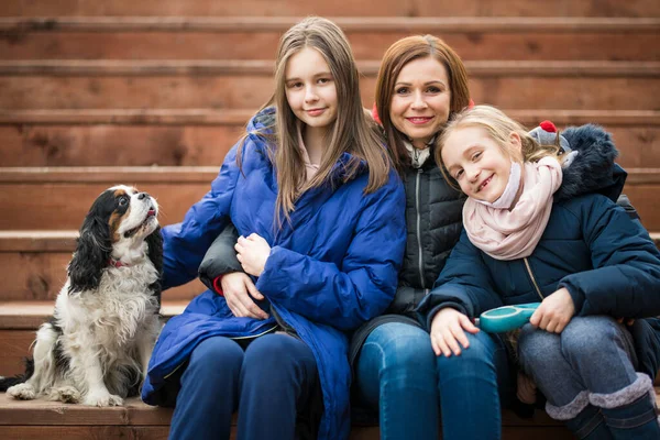 Mutter Mit Töchtern Und Hund Sitzen Auf Holztreppe — Stockfoto