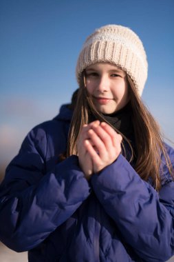 Kış dağlarının arka planında mavi ceketli bir kız.