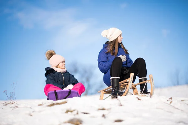 两个在冬天有雪橇的女孩 — 图库照片