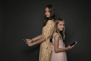 İki kız arkadaş akıllı telefondan selfie çekiyor.