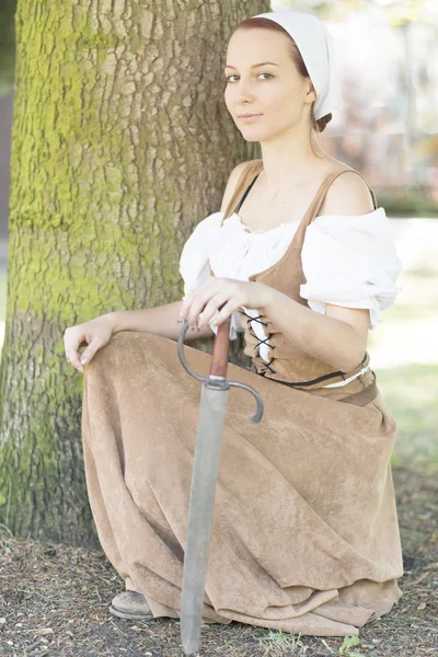 Жінка в середньовічній сукні з мечем — стокове фото