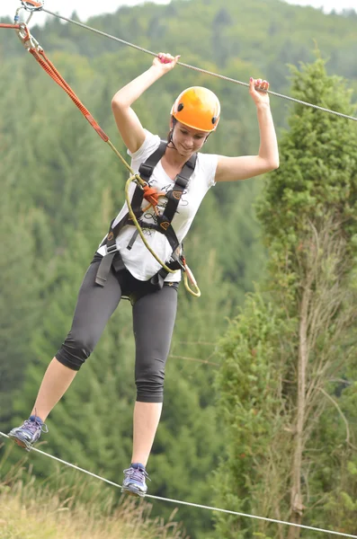 Happy girl climbing between trees — Stock Photo, Image