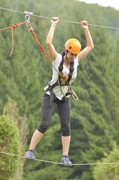 Happy girl climbing between trees — Stock Photo, Image