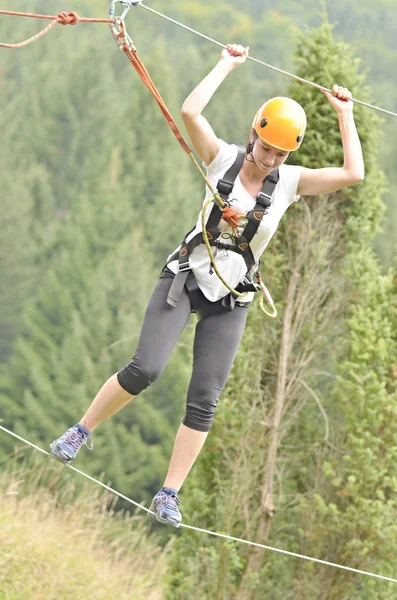 Happy girl climbing between trees — Stock Photo, Image